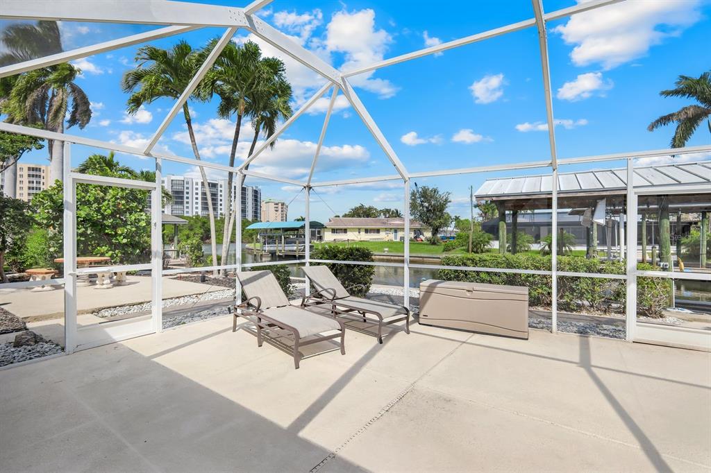 8552 Lagoon Road Fort Myers Beach, FL 33931 - Photo 22 of 33 a view of a patio with a table and chairs under an umbrella with a large tree