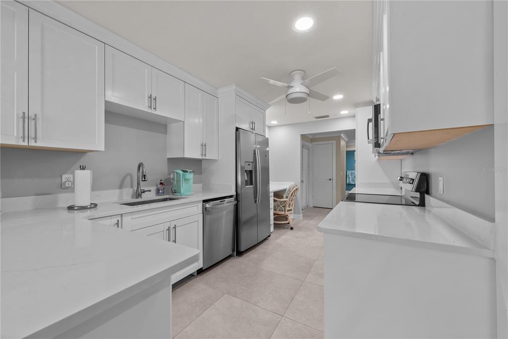 8552 Lagoon Road Fort Myers Beach, FL 33931 - Photo 5 of 33 a kitchen with stainless steel appliances a sink stove and refrigerator