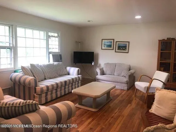 a living room with furniture wooden floor and window