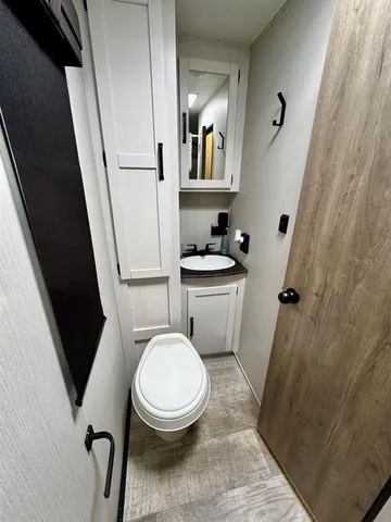 a white toilet sitting next to a sink and a mirror