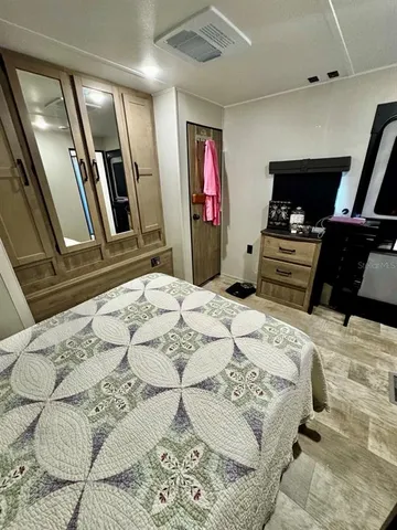 a bedroom with a bed and dresser with mirror