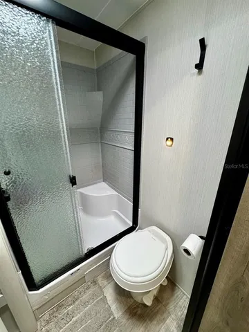 a bathroom with a toilet and a shower