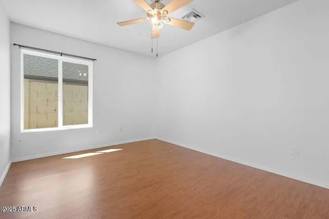 an empty room with a window and a fan