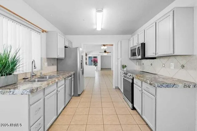 a large kitchen with stainless steel appliances granite countertop a stove a sink dishwasher and a refrigerator