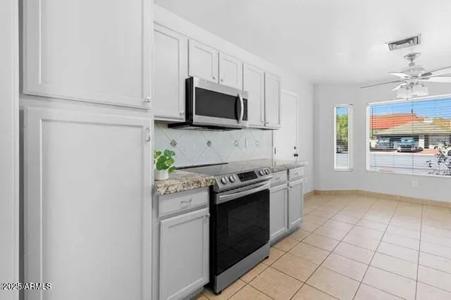 a kitchen with stainless steel appliances granite countertop a stove a microwave and a refrigerator