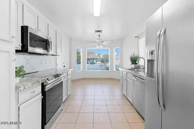a kitchen with stainless steel appliances granite countertop a refrigerator and a stove top oven