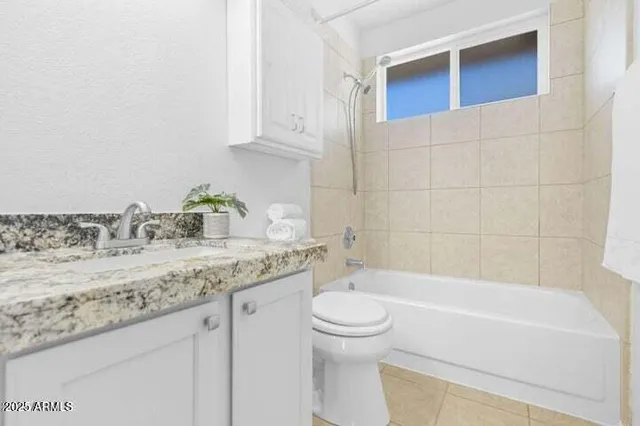 a bathroom with a granite countertop sink a toilet and bathtub