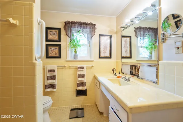 a bathroom with a sink a vanity and a large mirror