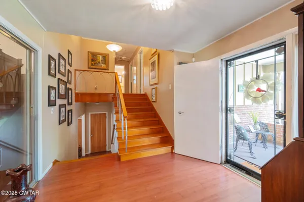 a view of a hallway with wooden floor and windows