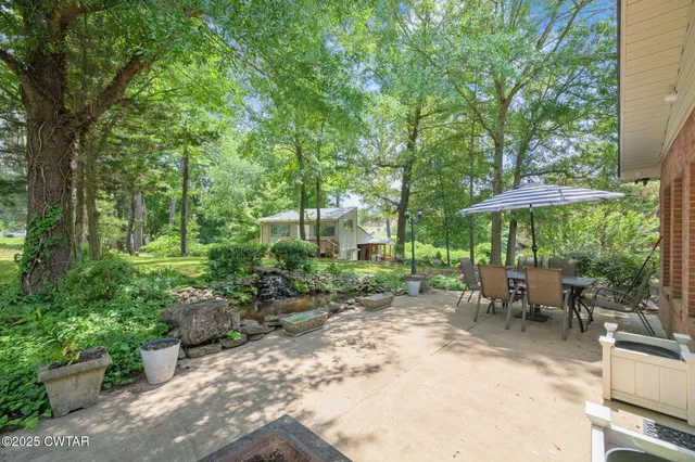 a view of a patio with table and chairs under an umbrella
