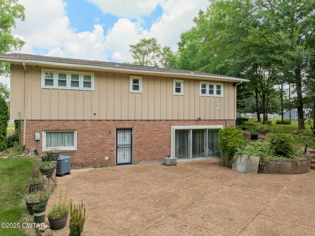 a front view of house with yard and trees around
