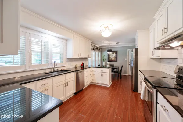 a large kitchen with a large window and stainless steel appliances