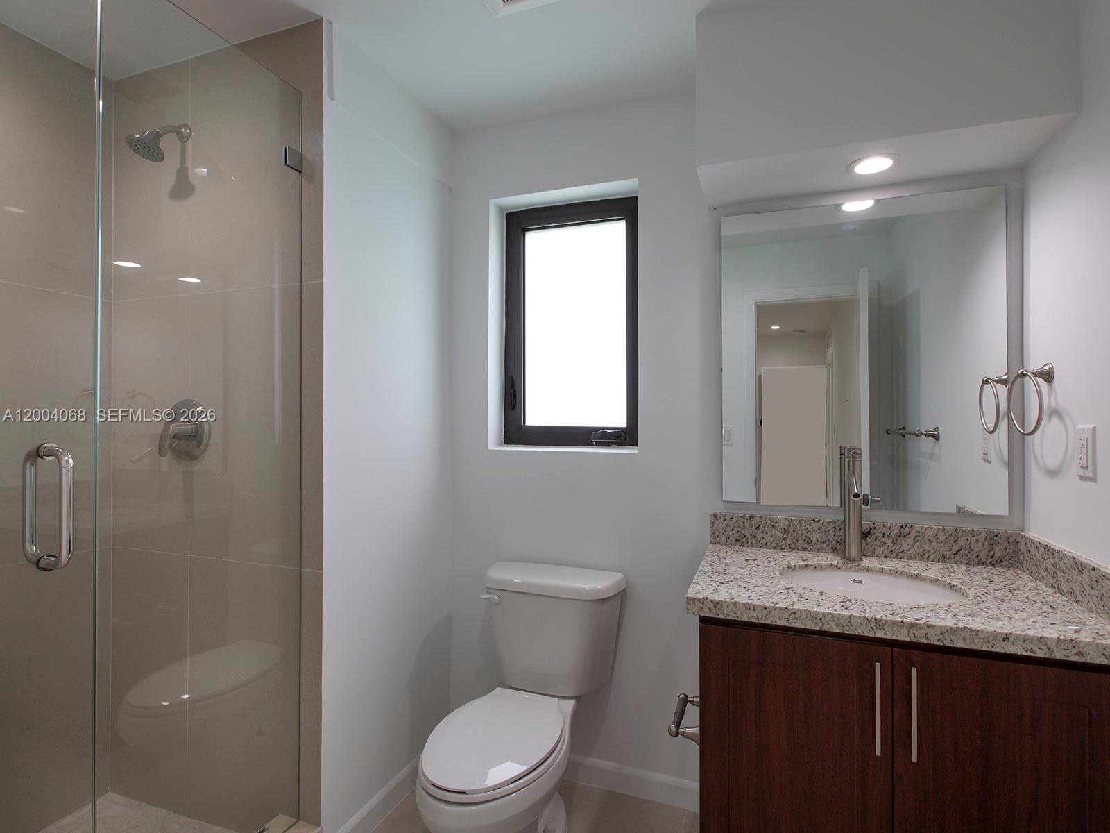 8790 Southwest 85th Street Miami, FL 33173 - Photo 14 of 20 a bathroom with a granite countertop sink a toilet and shower