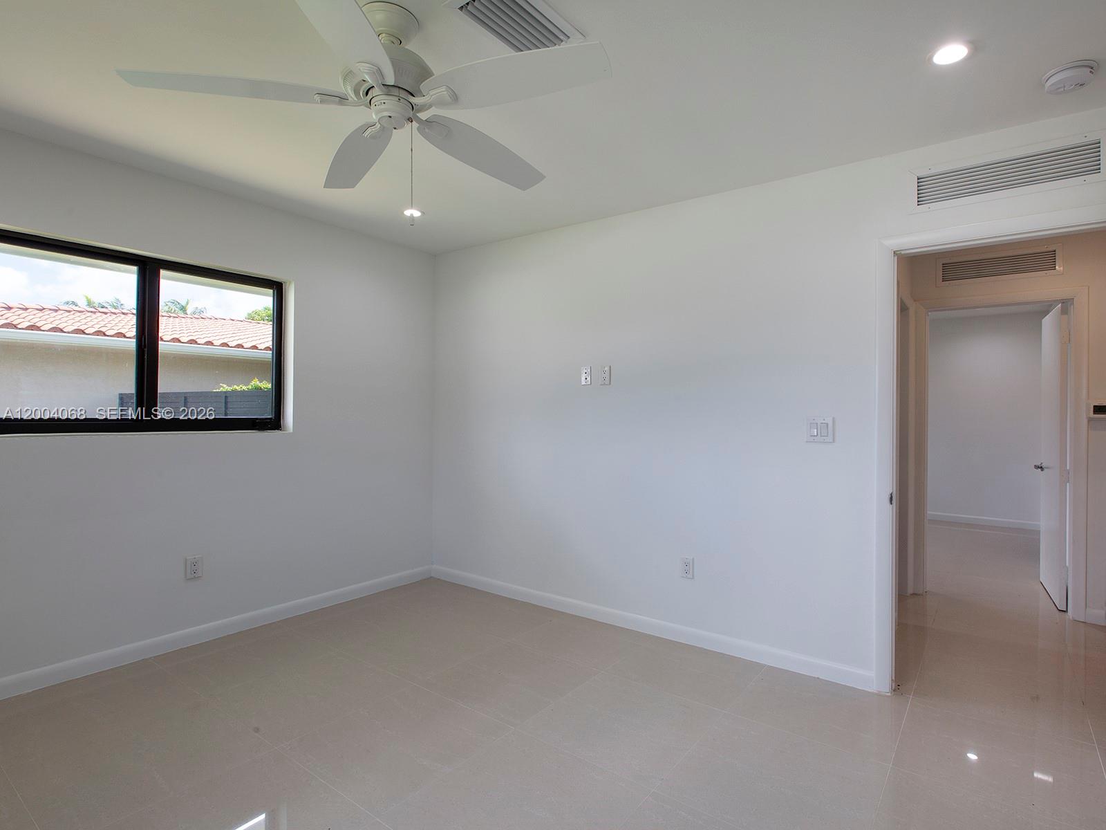 8790 Southwest 85th Street Miami, FL 33173 - Photo 17 of 20 an empty room with windows and fan