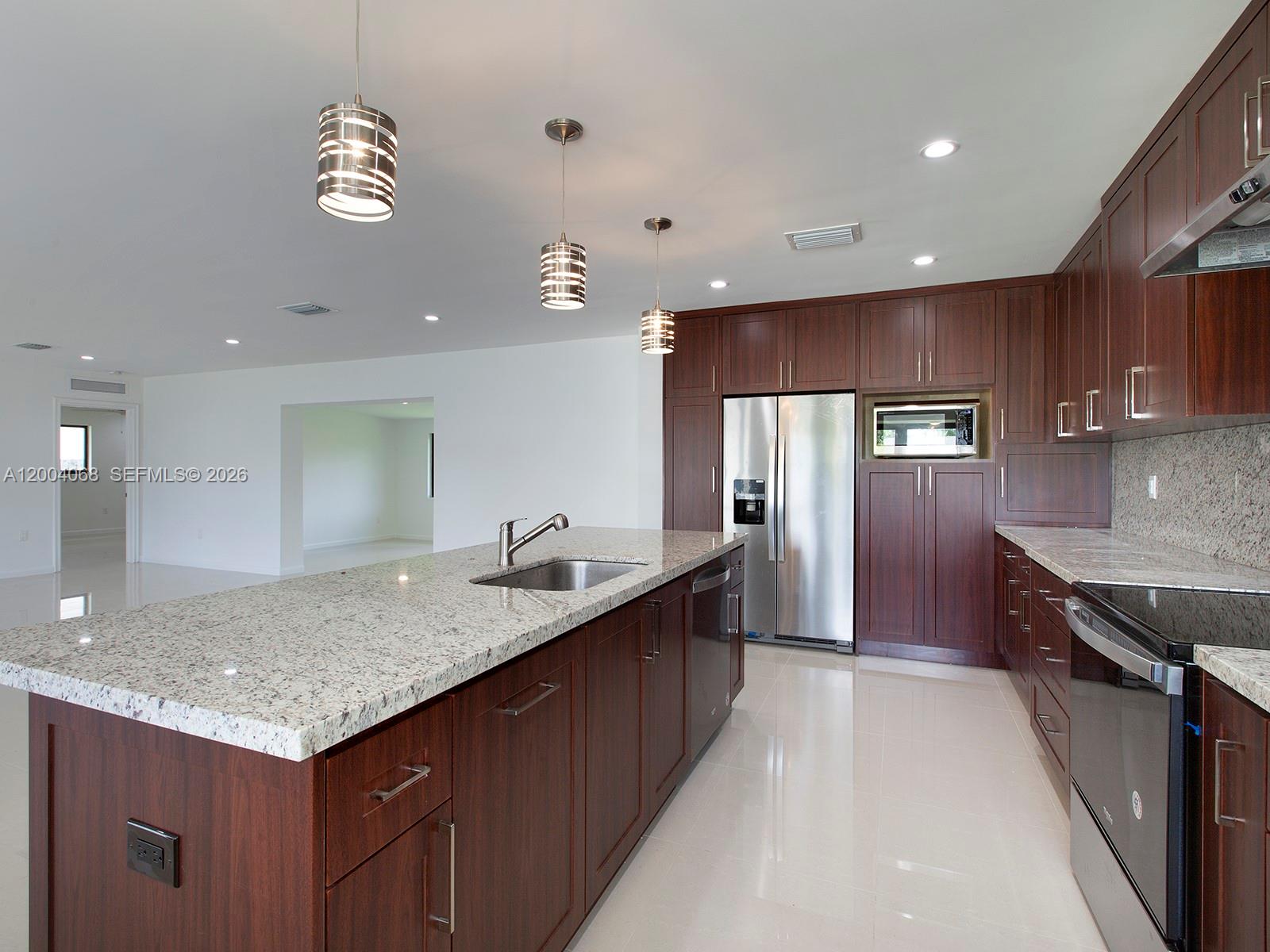 8790 Southwest 85th Street Miami, FL 33173 - Photo 7 of 20 a kitchen with a stove a refrigerator and wooden cabinets
