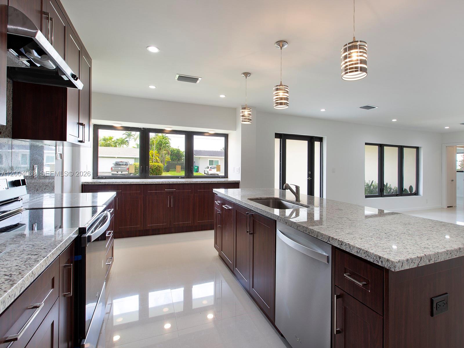 8790 Southwest 85th Street Miami, FL 33173 - Photo 8 of 20 a large kitchen with granite countertop a sink and a stove