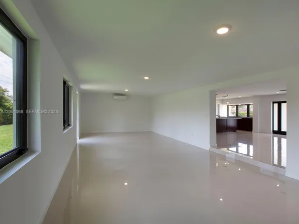 an empty room with large windows and entrance