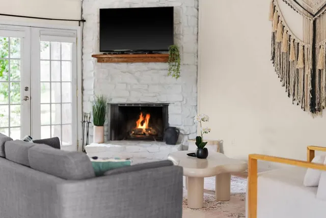 a living room with furniture a flat screen tv and a fireplace