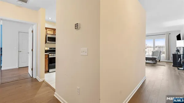 a view of a hallway with wooden floor and a living room