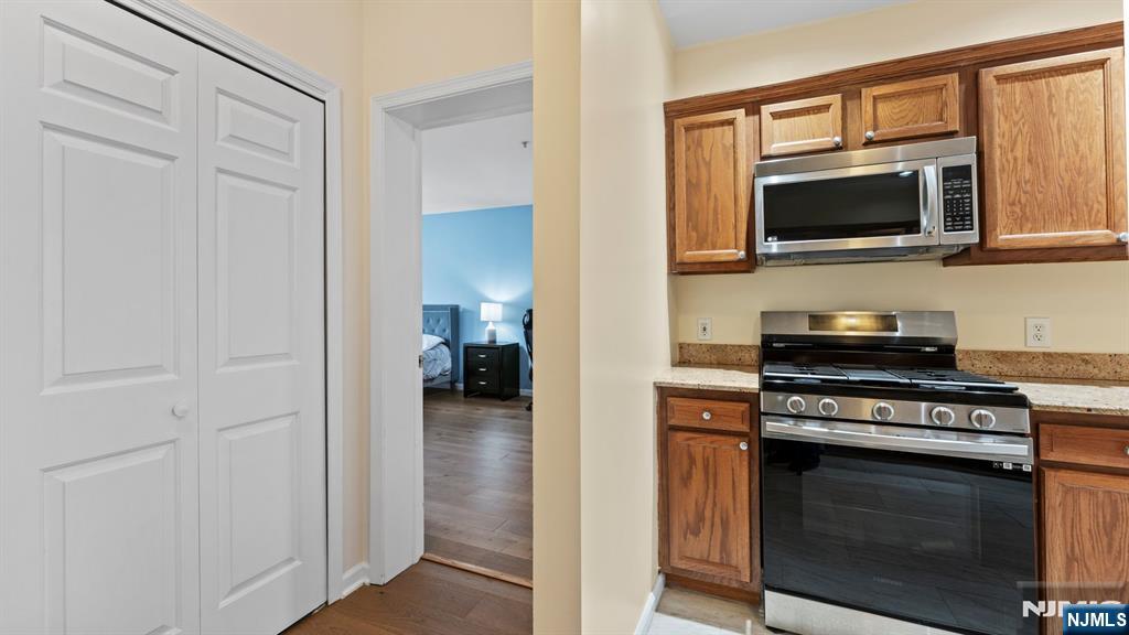 344 The Promenade, Unit 344 Edgewater, NJ 07020 - Photo 16 of 44 a kitchen with stainless steel appliances a stove microwave and sink