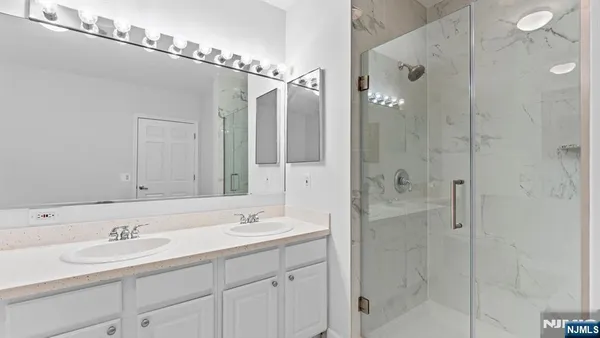a bathroom with a shower sink and mirror