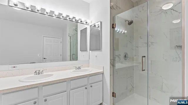a bathroom with a shower sink and mirror
