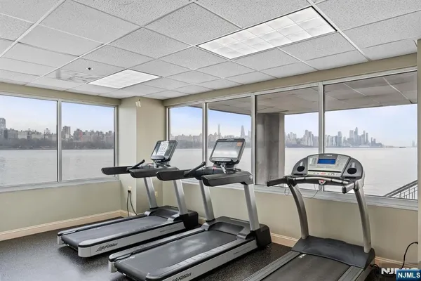 a room with gym equipment and large windows