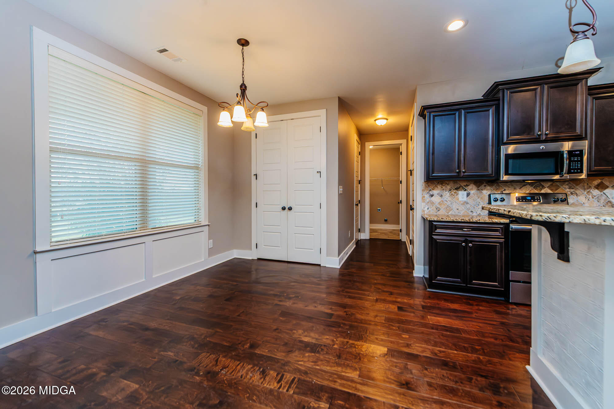 112 Agriculture Lane Perry, GA 31069 - Photo 14 of 40 a kitchen with kitchen island granite countertop wooden floors and a view of living room
