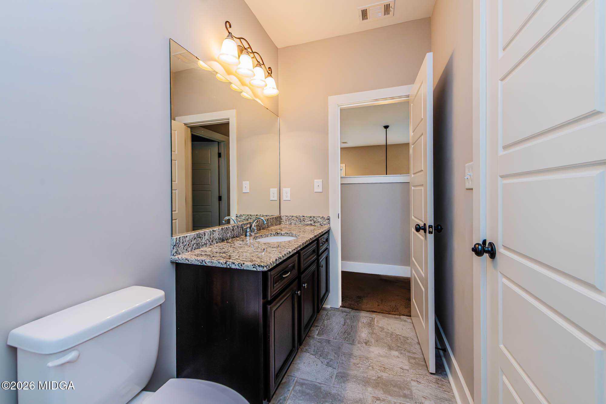 112 Agriculture Lane Perry, GA 31069 - Photo 28 of 40 a bathroom with a granite countertop sink toilet and mirror