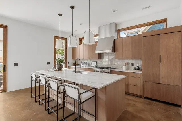 a kitchen with stainless steel appliances a sink a stove and a wooden floors