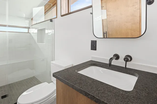 a view of a patio with table and chairs and wooden fence
