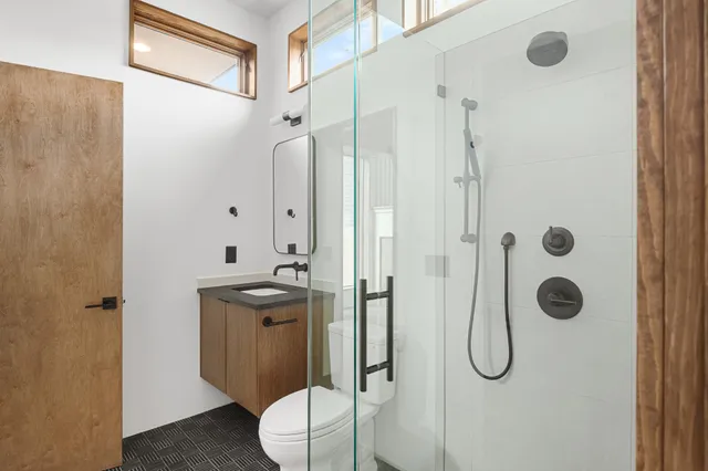 a bathroom with a granite countertop sink toilet and shower
