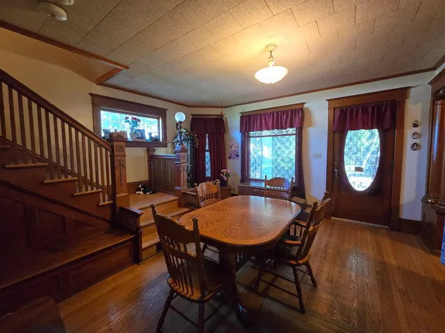 a dining room with furniture a window and wooden floor