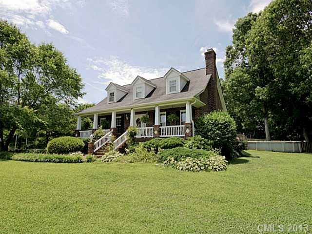 a front view of a house with a garden and plants