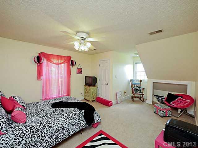 611 East Sandy Ridge Road Monroe, NC 28112 - Photo 11 of 16 a bedroom with a bed and a chandelier