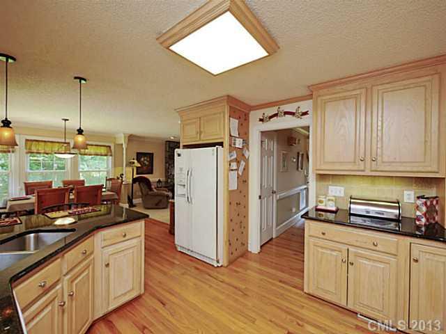611 East Sandy Ridge Road Monroe, NC 28112 - Photo 8 of 16 a kitchen with stainless steel appliances granite countertop a refrigerator a oven and white cabinets with wooden floors