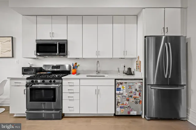 a kitchen with refrigerator a stove and a microwave