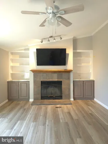 a view of empty room with wooden floor fireplace and a window