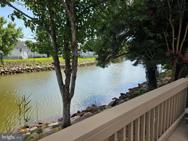 a view of a lake with a table and chairs under an umbrella