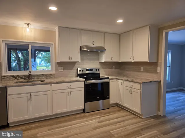 a kitchen with a sink cabinets and wooden floor