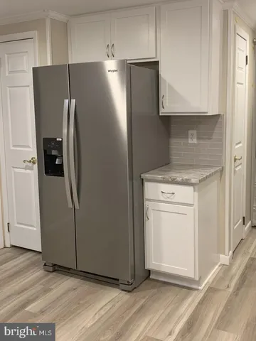 a kitchen with metallic refrigerator and cabinets