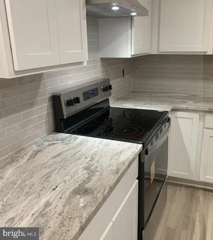 a kitchen with granite countertop a sink and a stove