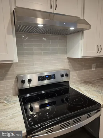 a stove top oven sitting inside of a kitchen
