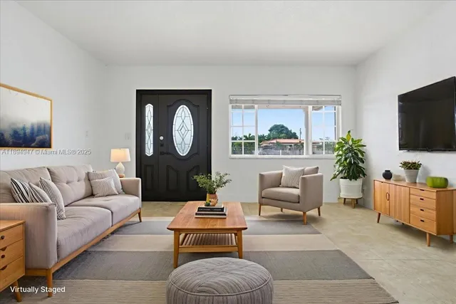 a living room with furniture a flat screen tv and a large window