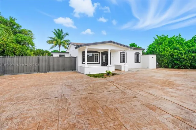 a front view of a house with a yard and potted plants
