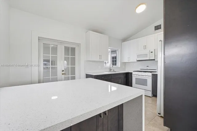 a kitchen with granite countertop a sink cabinets stainless steel appliances and a counter top space