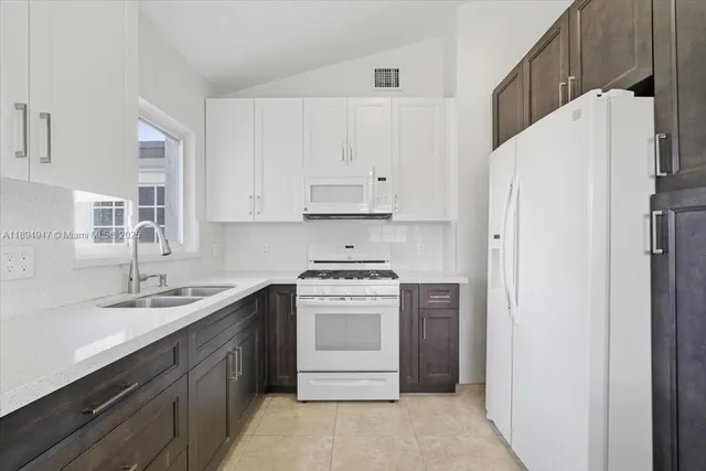 a kitchen with a white cabinets sink and white stainless steel appliances