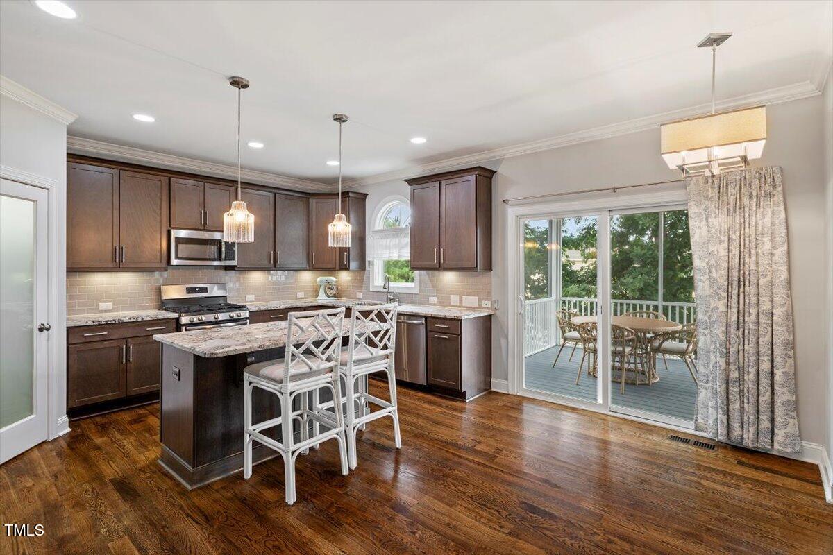357 Marshcroft Way Rolesville, NC 27571 - Photo 11 of 41 a kitchen with stainless steel appliances granite countertop a stove top oven a sink dishwasher a dining table and chairs with wooden floor