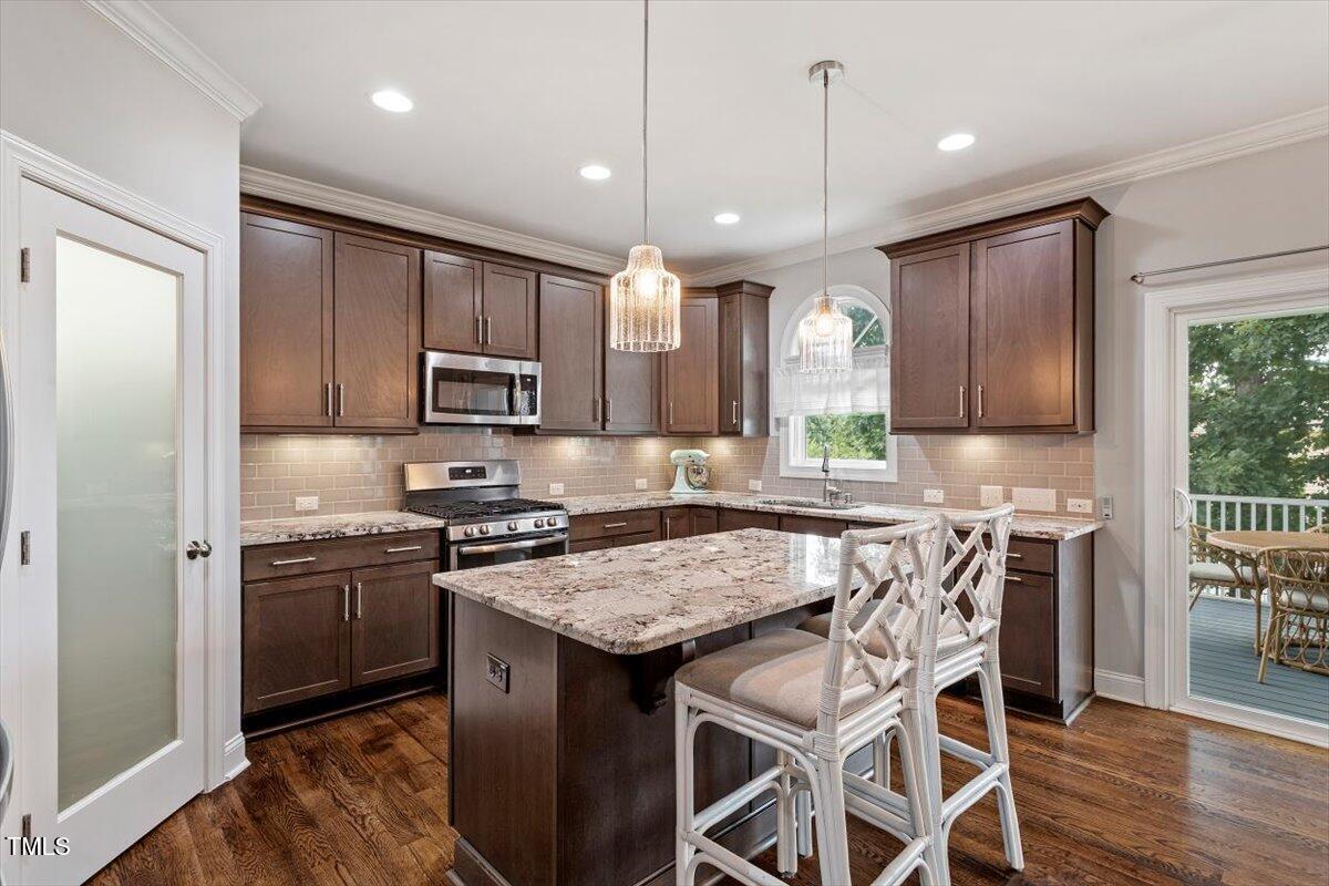 357 Marshcroft Way Rolesville, NC 27571 - Photo 16 of 41 a kitchen with granite countertop stainless steel appliances a sink stove and refrigerator