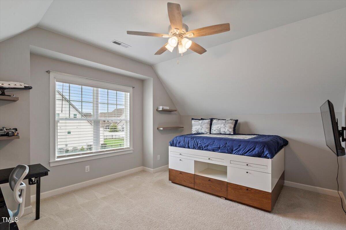 357 Marshcroft Way Rolesville, NC 27571 - Photo 27 of 41 a spacious bedroom with a bed and a chandelier